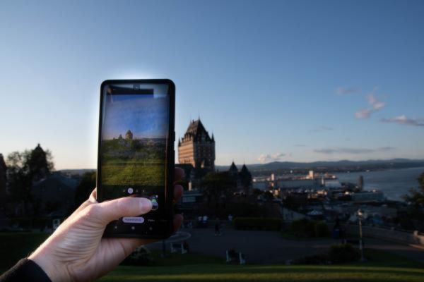 hand with cell photo taking a photo of the fairmont chateau frontenac